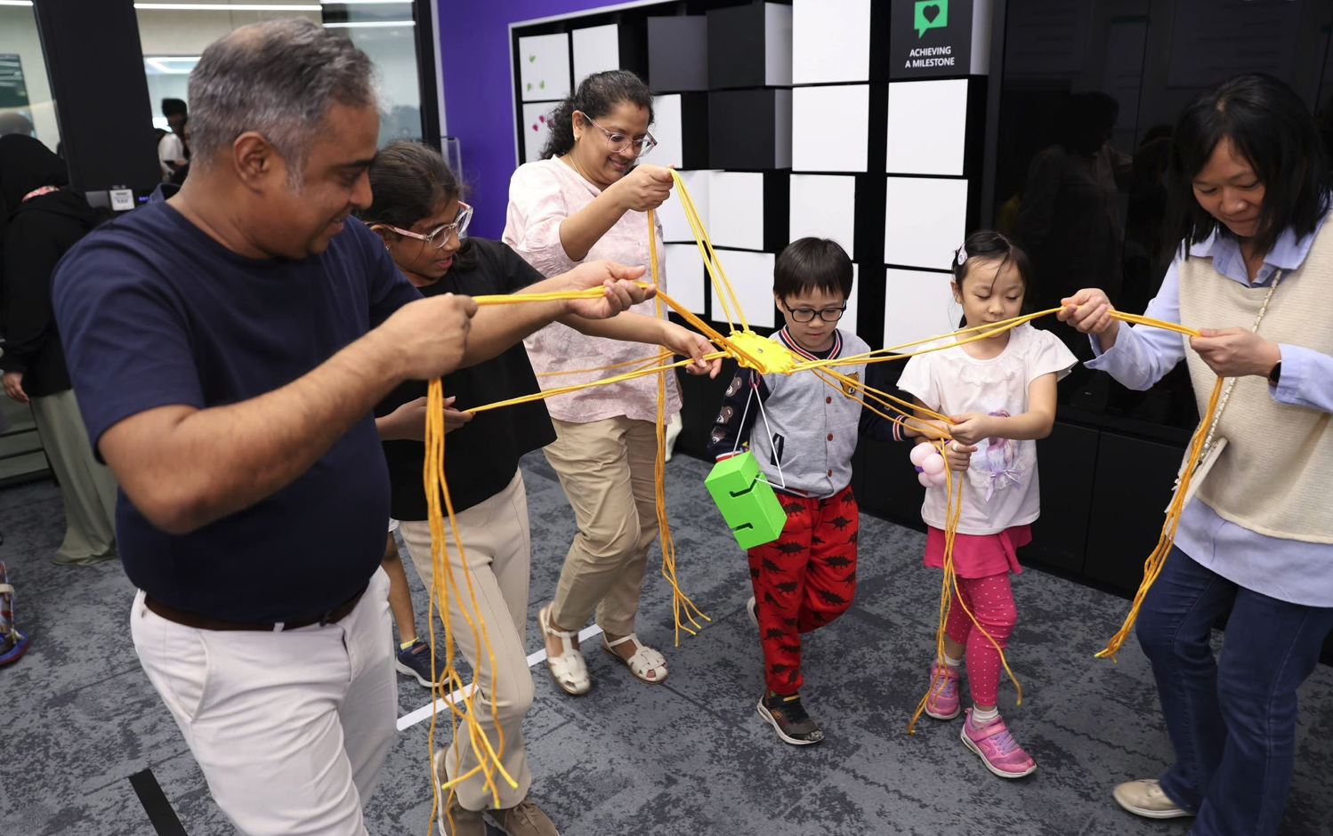 Colleagues taking part in a team-building string activity at a corporate event