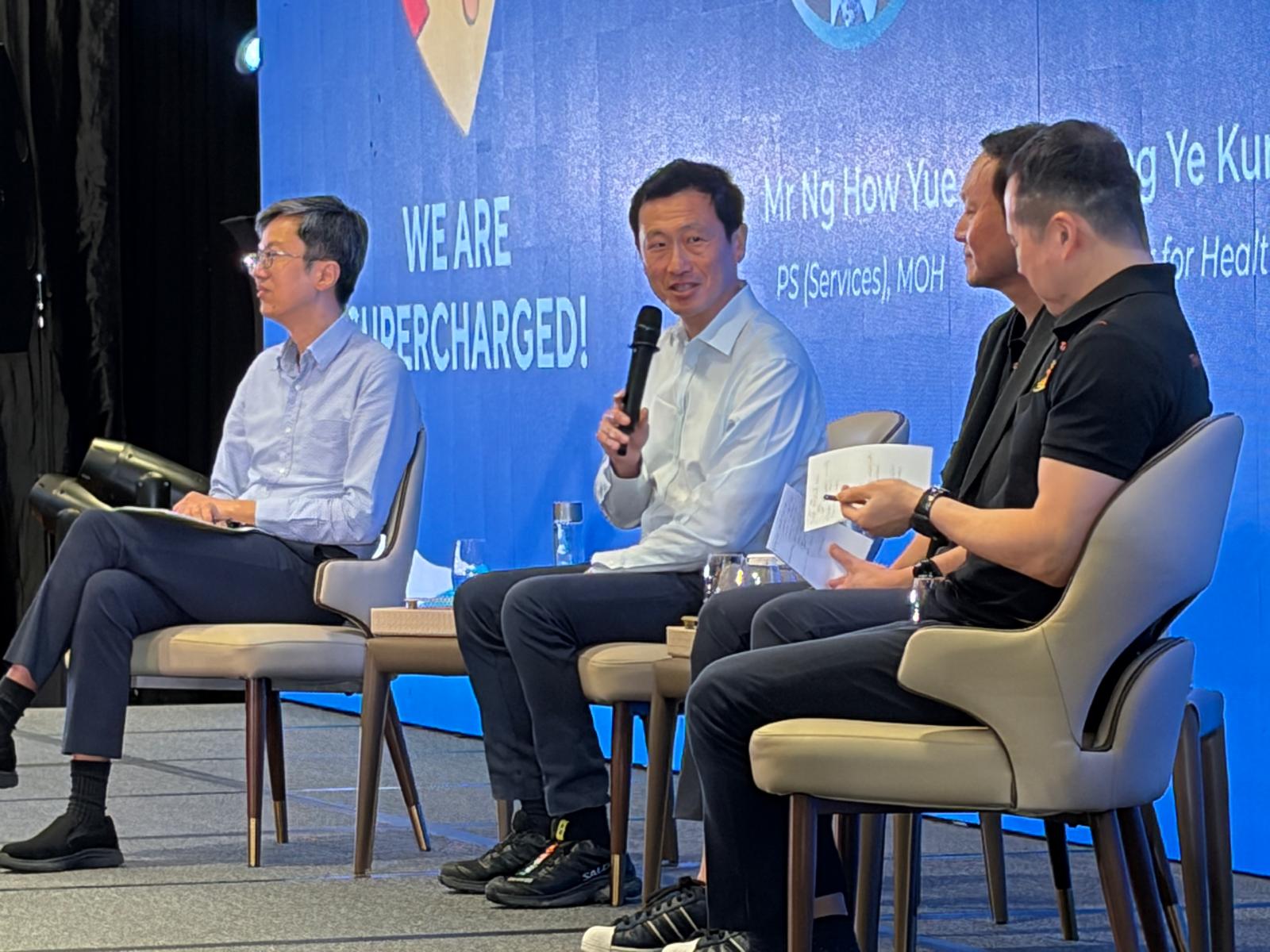 Seated panel discussion on stage in front of a large blue LED backdrop