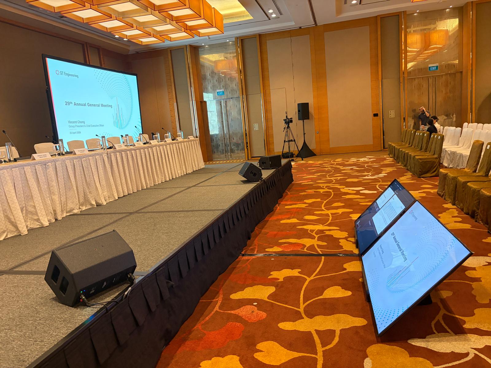 ST Engineering annual general meeting room set with a presentation screen, stage table, and confidence monitors