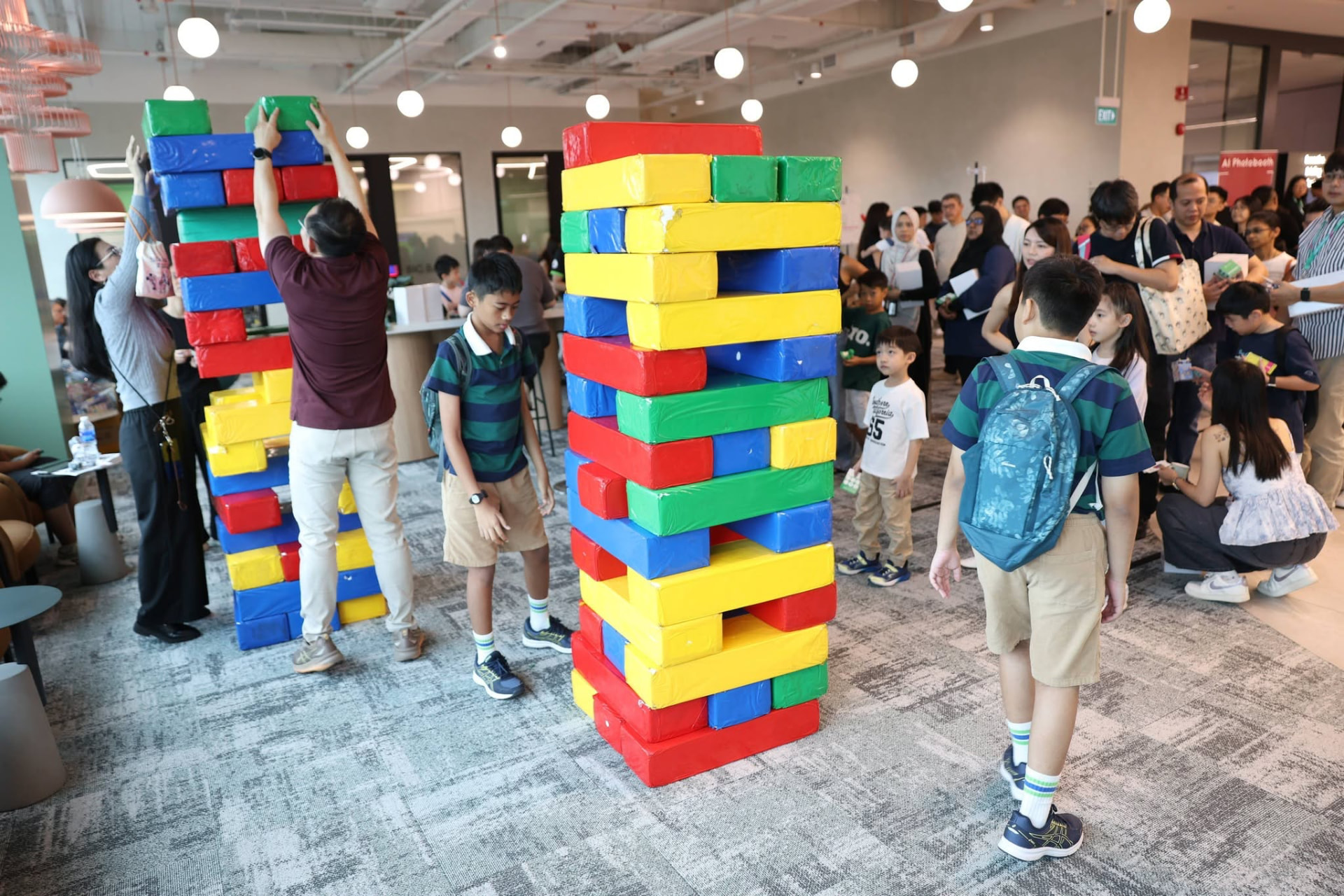 Families stacking giant colourful foam blocks at a corporate family day activation