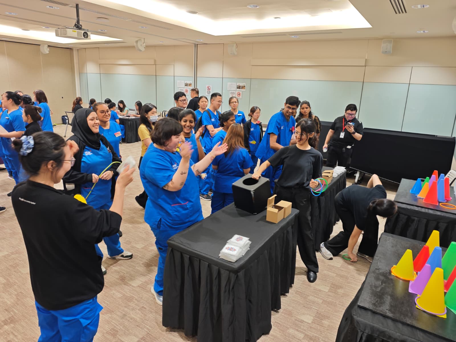 Nurses playing ring toss carnival games run by event crew at a hospital celebration