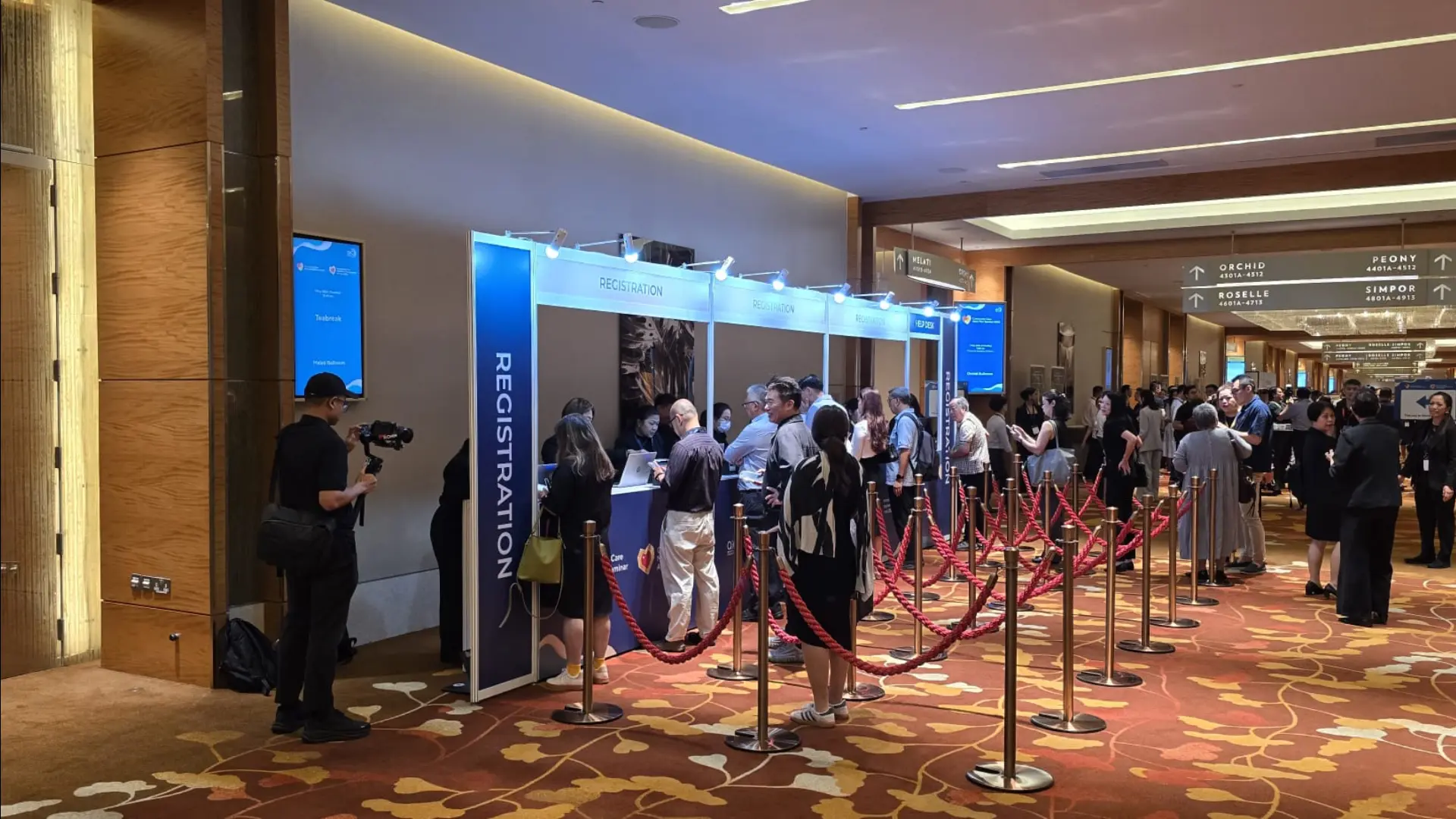 Attendees checking in at branded registration counters with digital signage