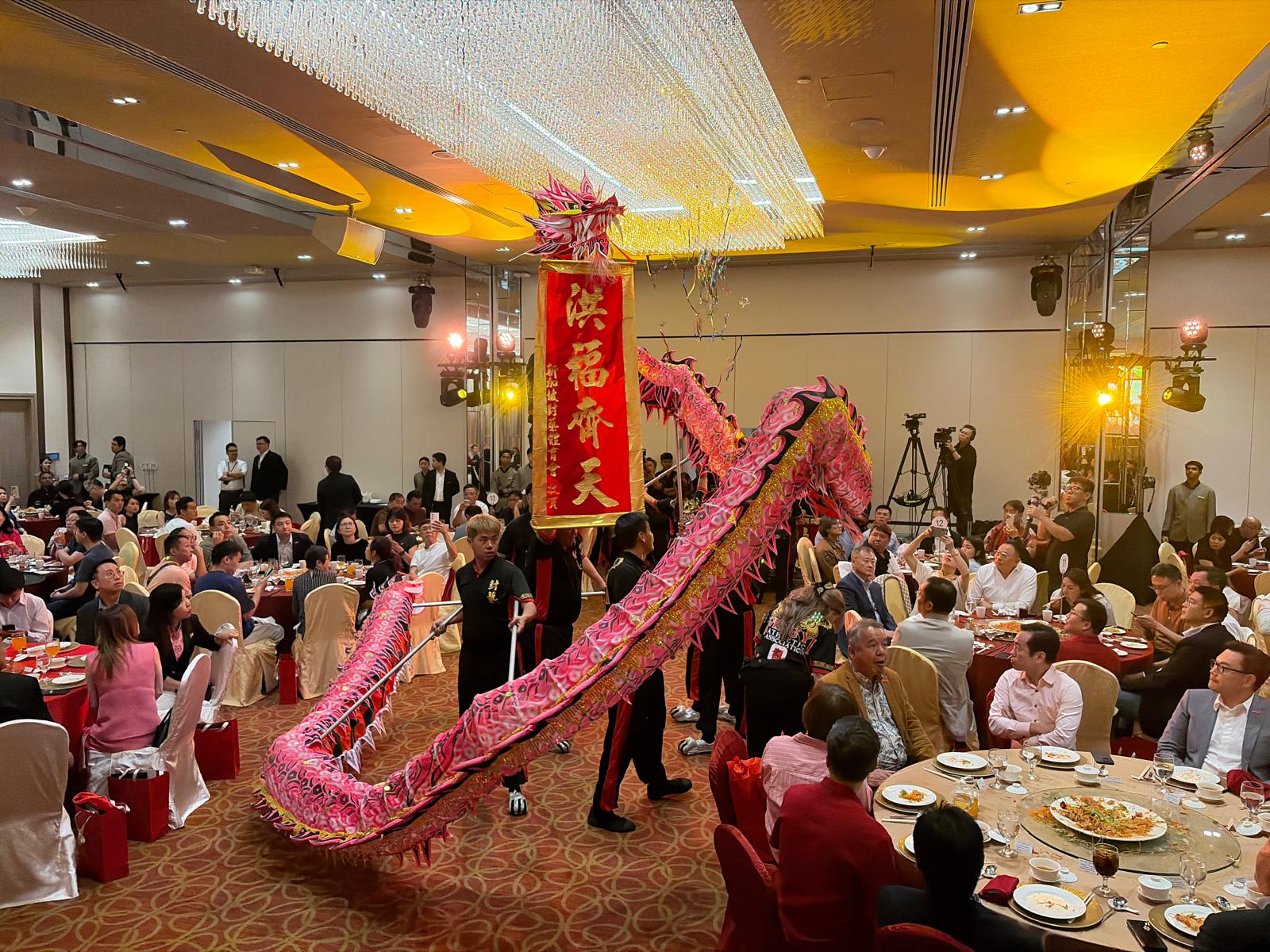 Traditional lion dance performance weaving through seated guests at a corporate gala dinner in Singapore