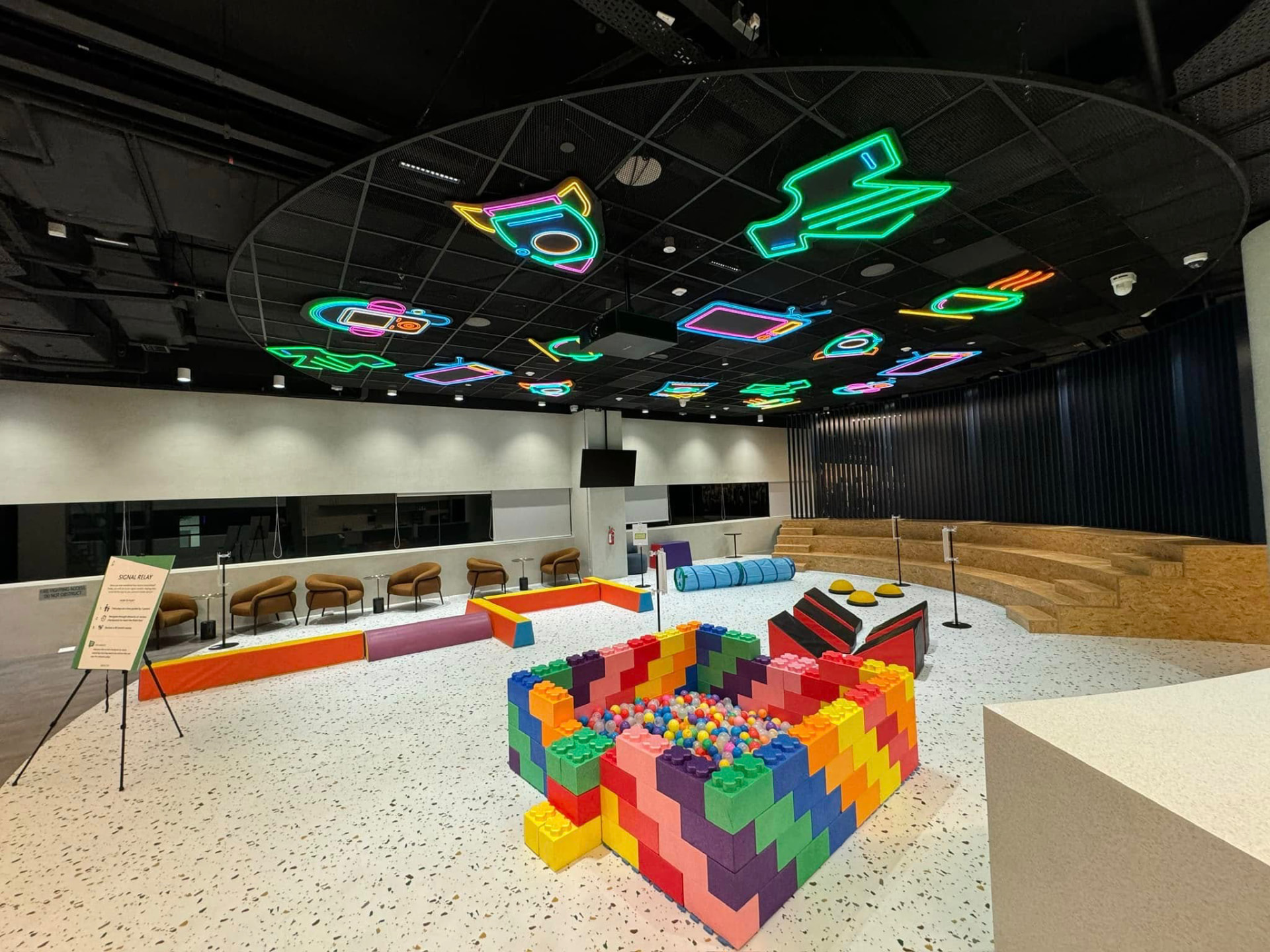 Experiential play zone with neon ceiling installation and modular block build