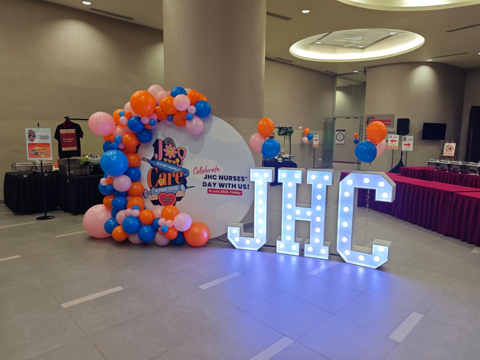 Balloon arch and illuminated marquee JHC letters at a Jurong Health Council Nurses' Day celebration