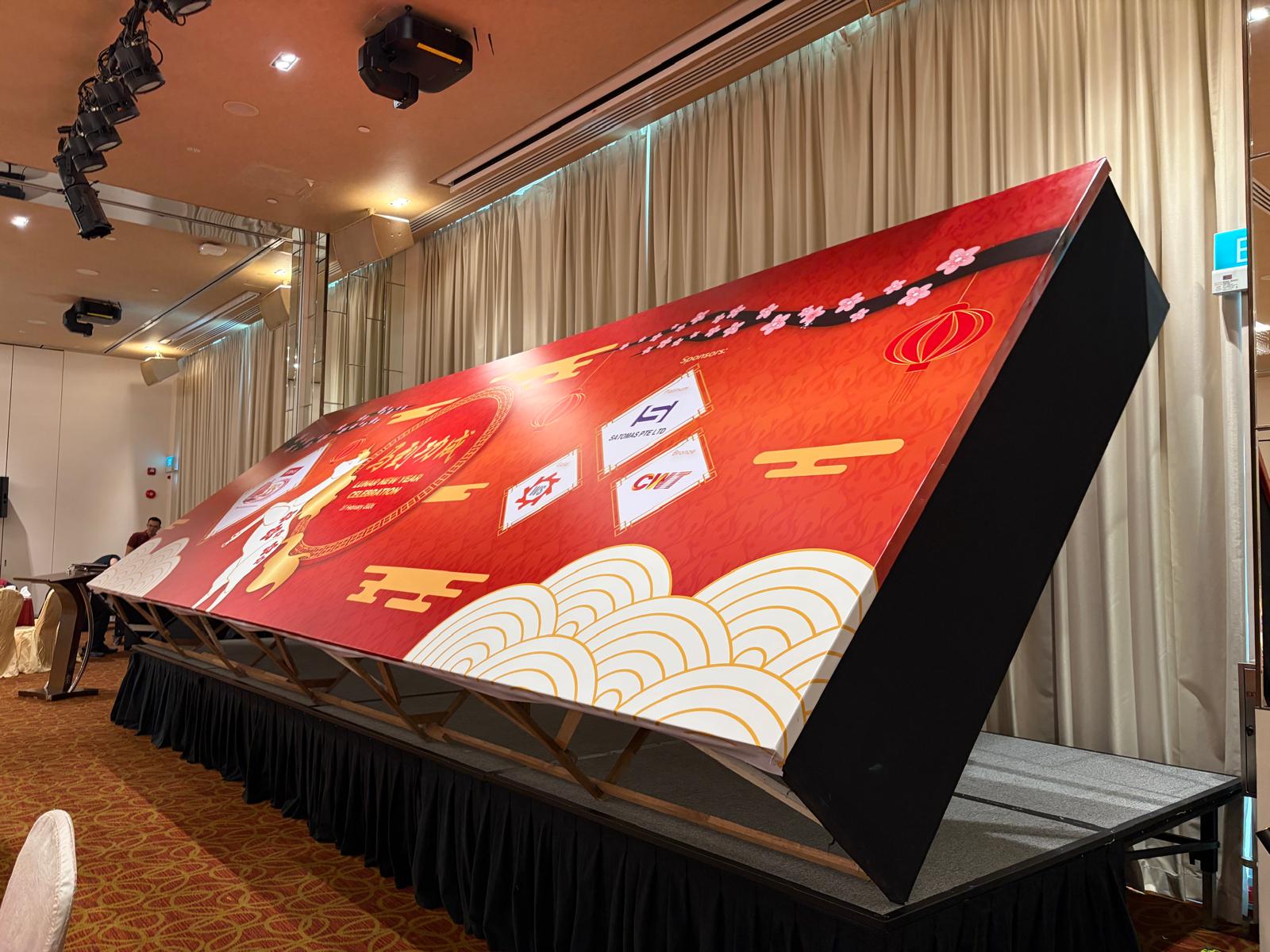 Custom fabricated Lunar New Year stage backdrop with sponsor branding in a ballroom