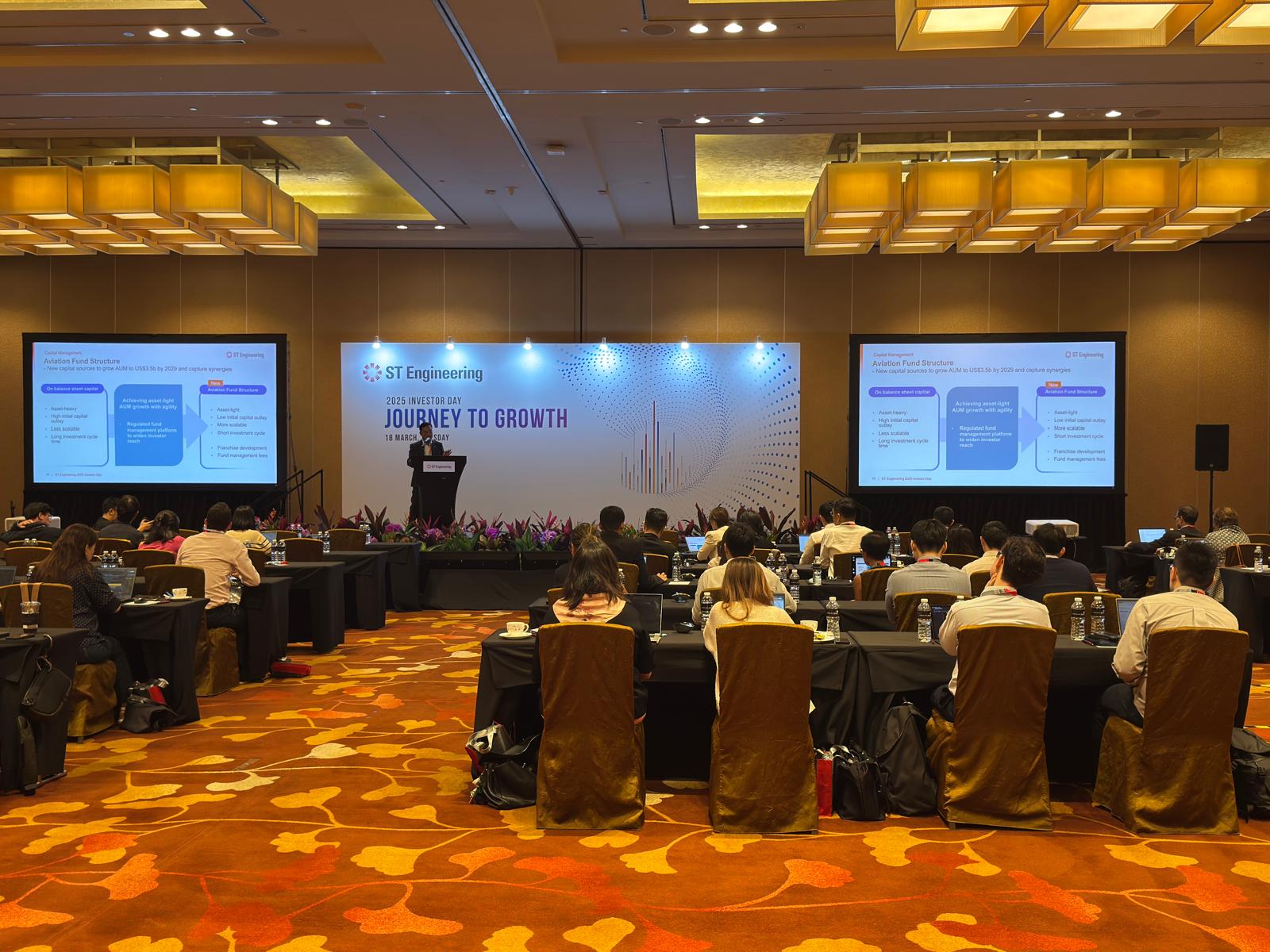 ST Engineering investor day presentation in a ballroom with attendees seated before the stage