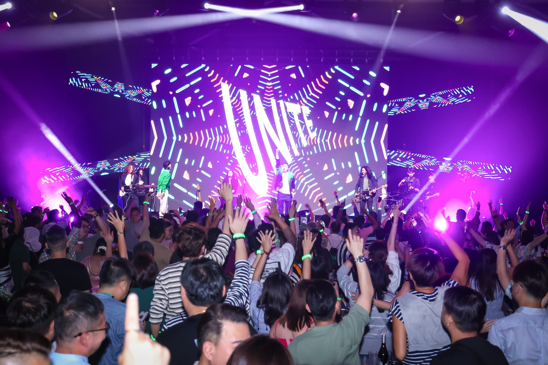 Live concert production with vibrant stage lighting, LED visuals and an engaged audience